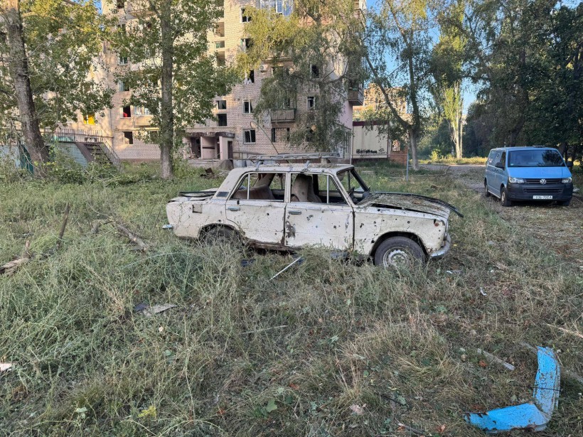 Пошкоджений автомобіль у дворі зруйнованої окупантами багатоповерхівки