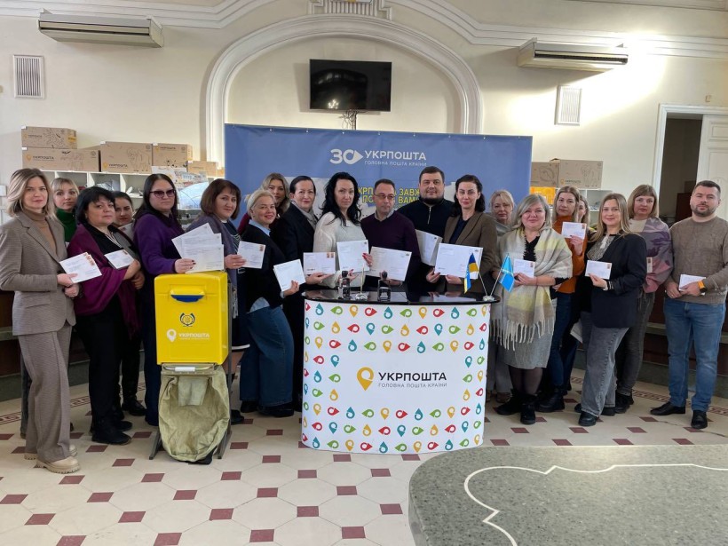 Спільне фото. Представники громади та працівники АТ «Укрпошта» в місті Дніпро. У руках тримають вітальні листи.