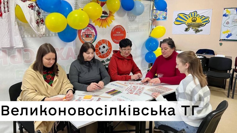 Спеціалісти Великоновосілківської громади за столом опрацьовують ескіз майбутньої вишиванки
