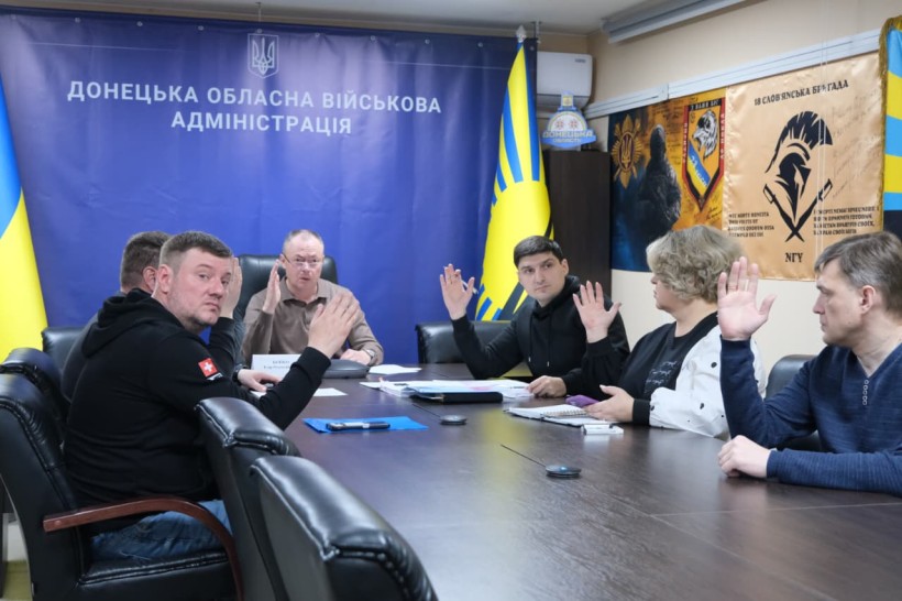 Учасники наради голосують.