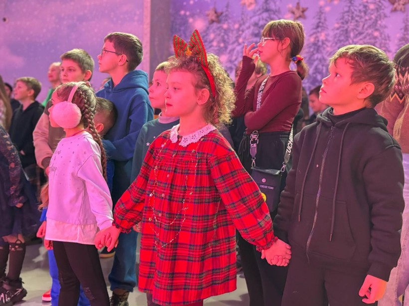 Діти грають в ігровій програмі з костюмованими аніматорами та отримують подарунки