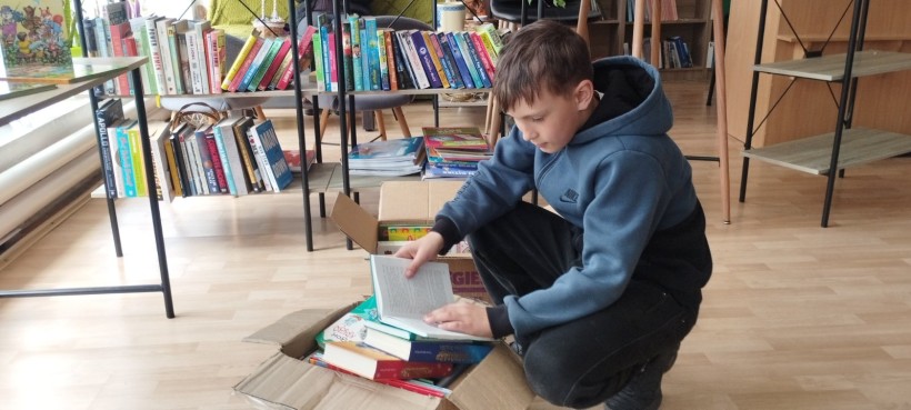 Хлопчик тримає розкриту книжку в руках