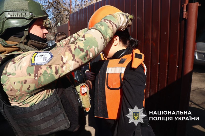 Поліцейський одягає захисний шолом на дитину.