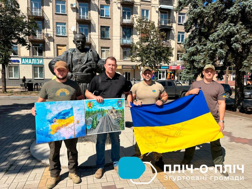 Представники Дружківської та Жмеринської громад на площі в Дружківці тримають прапор та картину