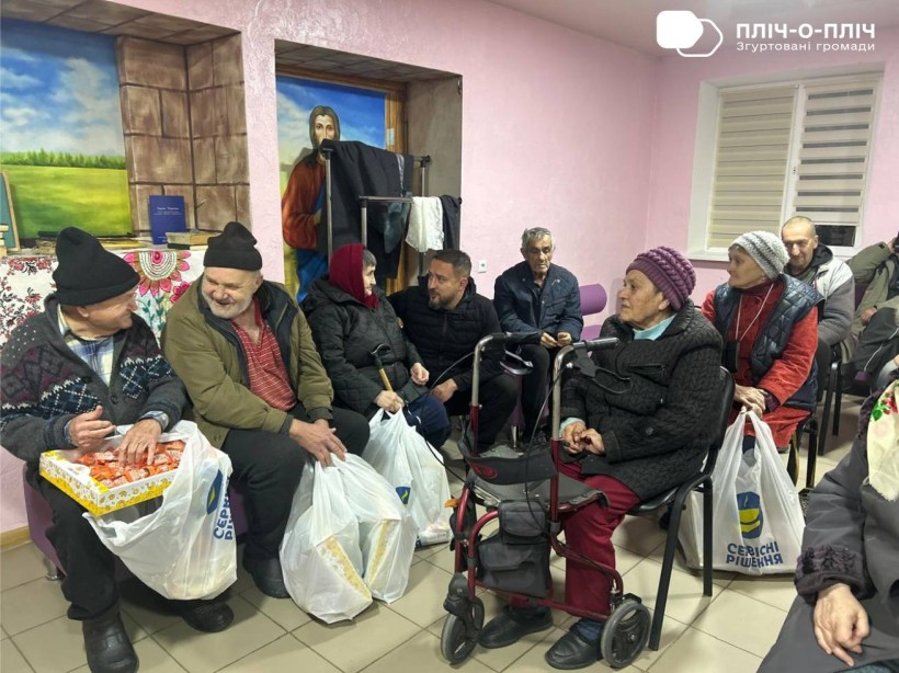 Будинок ветеранів. Переселенці з Часовоярської громади, люди похилого віку, тримають гуманітарні набори.