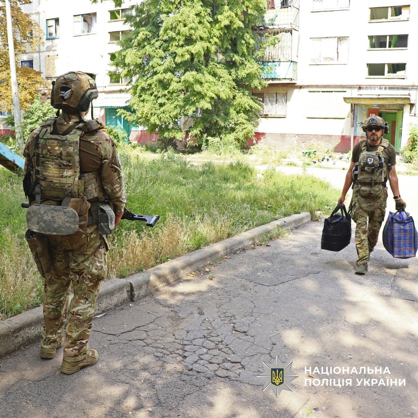 Поліцейський несе речі людей
