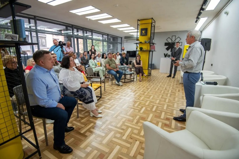 Відвідувачі простору сидять на стільцях та слухають доповідача.
