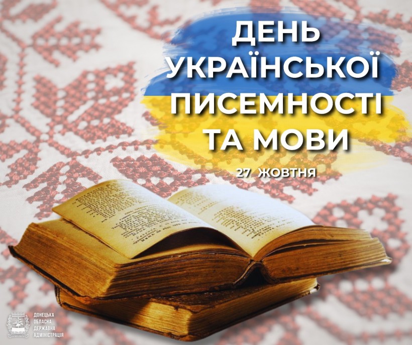 Стара книга на вишитій тканині з українськими кольорами. Текст на ній гласить: «День української літератури та мови, 27 жовтня». Вінтажний, культурний свято.