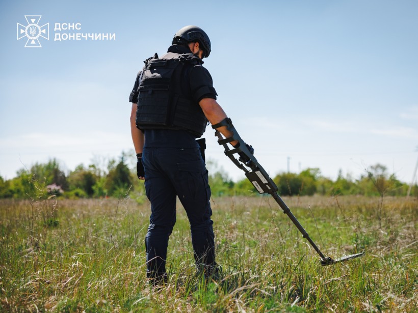 Сапер ДСНС за допомогою металошукача обстежує територію