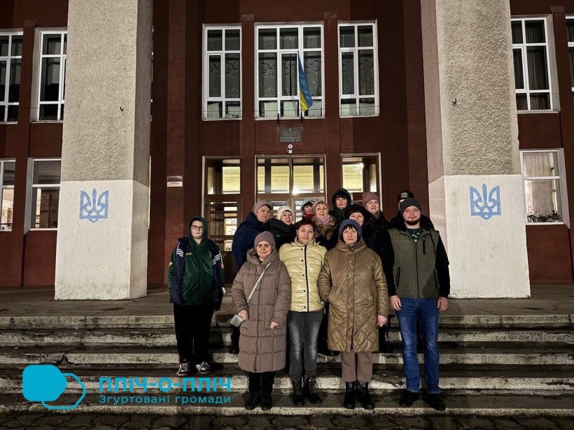 Спільне фото. ВПО з Донеччини біля фасаду будинку, стоять на сходах.