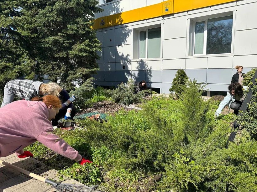 Переселенки з Донеччини беруть участь у весняній толоці: прибирають клумби біля гуманітарного хабу
