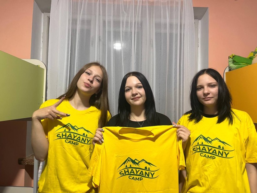 Троє дівчат хизуються новими футболками з логотипом табору