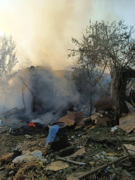 Зруйнований та згорілий одноповерховий будинок та пожежа на подвір'ї.