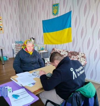 Літня жінка заповнює заявку на отримання палива