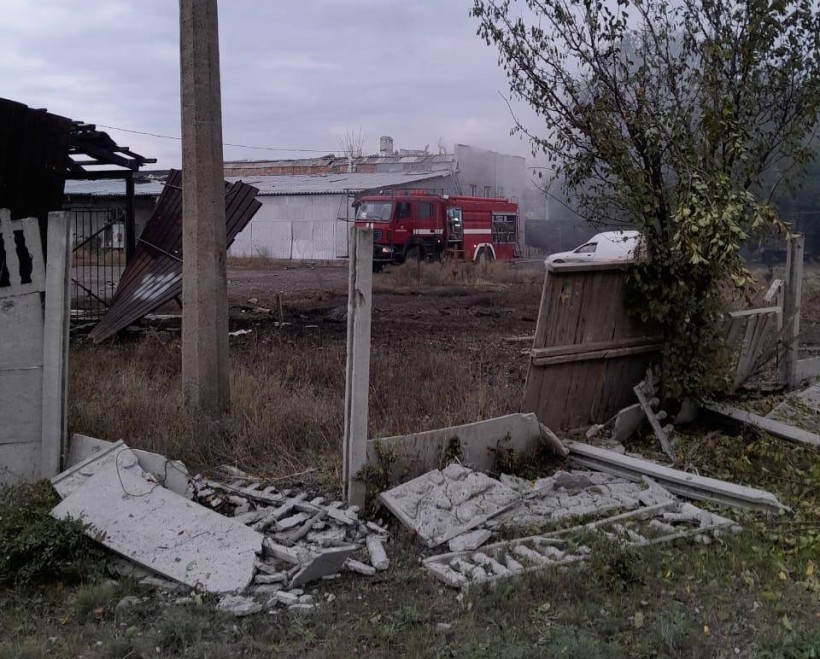 Зруйновані будівля тушить пожежна машина