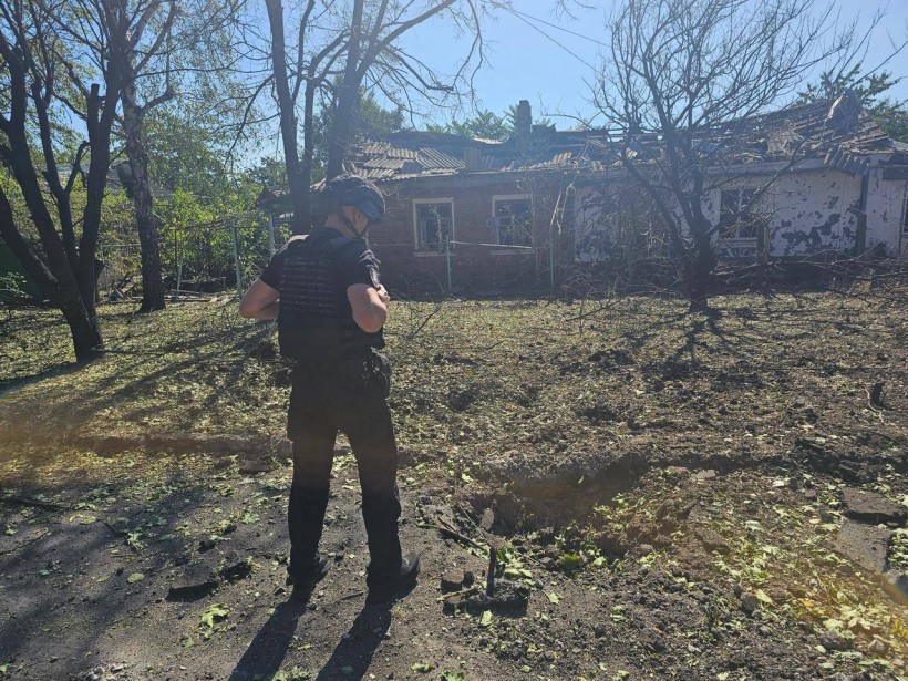 Правоохоронець стоїть поруч із зруйнованим одноповерховим будинком