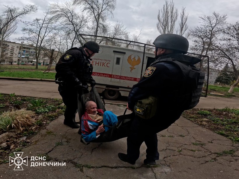 Рятувальники ДСНС евакуюють лежачого чоловіка.