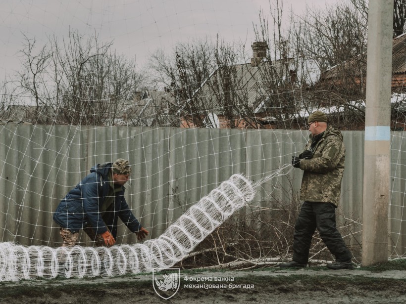 Бійці 4-ї механізованої бригади зводять антидронові сітки над населеним пунктом Донеччини
