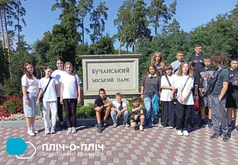 Діти зі Слов'янської громади стоять біля стенда"Бучанський міський парк"