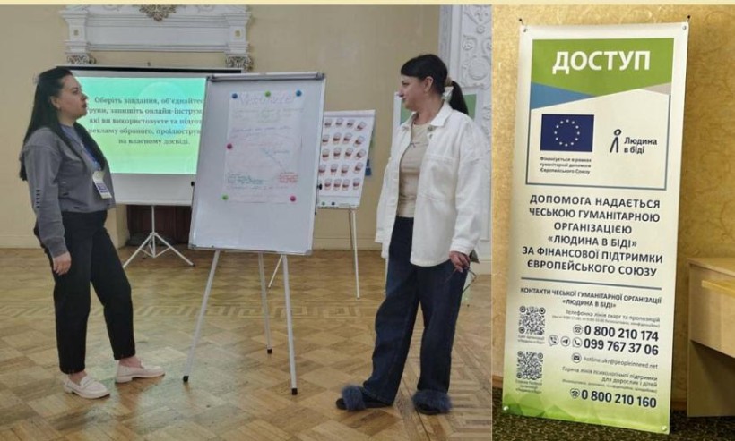 Дві жінки-педагогині стоять біля фліпчарту з нотатками, обговорюючи результати роботи під час тренінгу з тьюторських компетентностей.