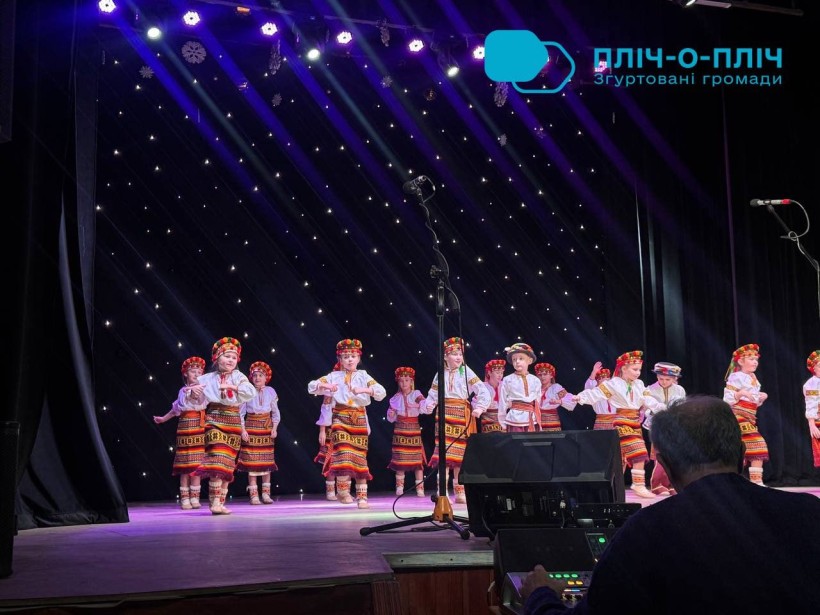 Артисти на сцені.
У народних костюмах виконують танок.