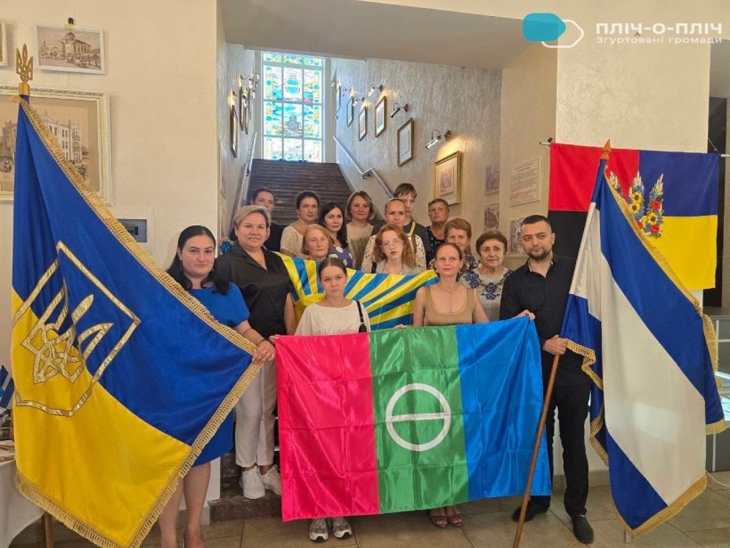 Учасники відкриття виставки тримають прапори Бахмута та України