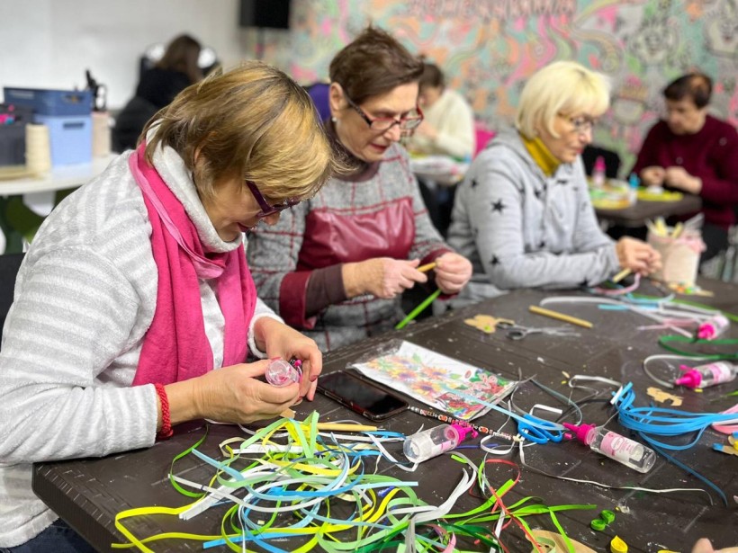 Арттерапія в дії: жінки склеюють смужки паперу за столом