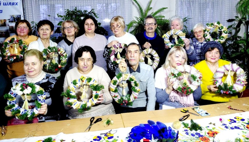 Учасники майстер-класу плетуть віночки під наставництвом музейників