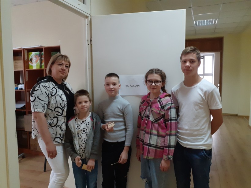 Учасники квесту на станції «Загадкова» — діти з педагогом позують біля дверей із відповідною назвою