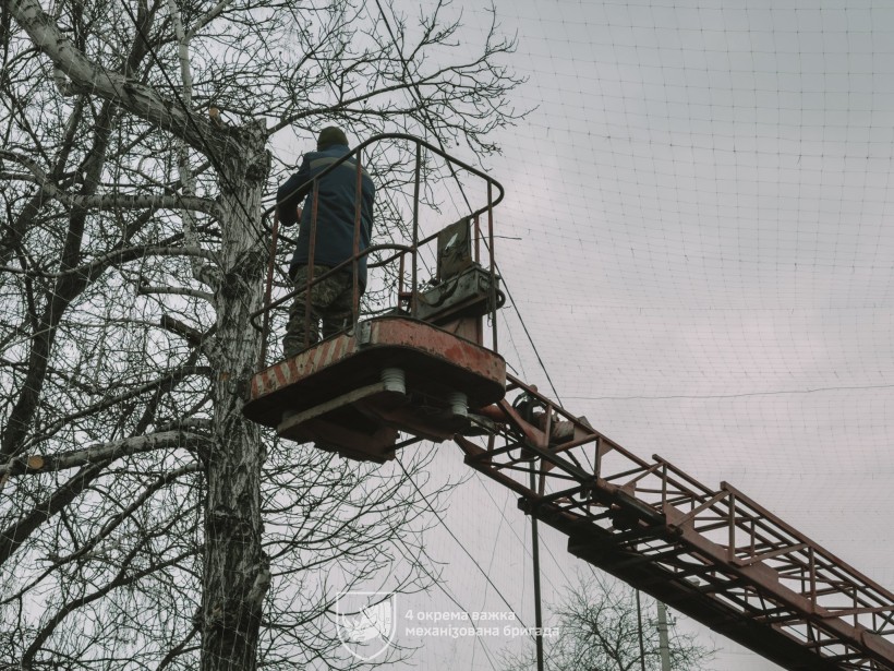 Бійці 4-ї механізованої бригади зводять антидронові сітки над населеним пунктом Донеччини