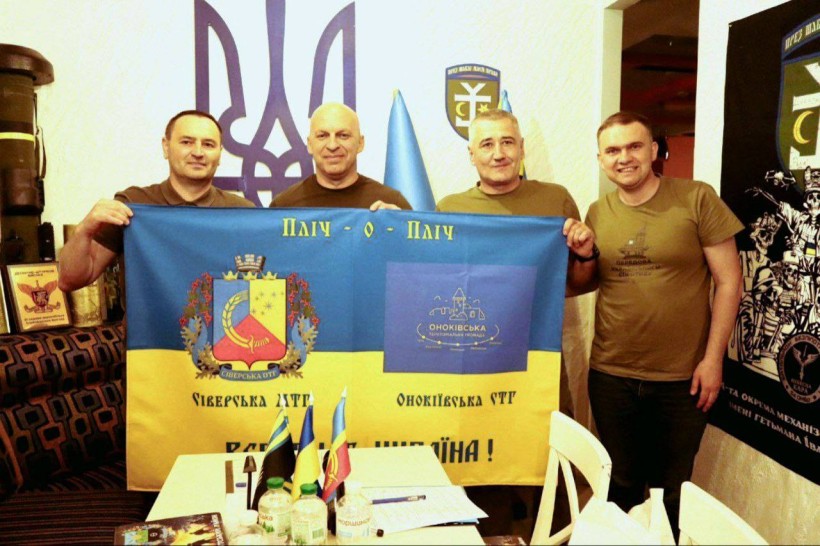 Начальник Донецької ОВА Вадим Філашкін разом з керівниками Сіверської та Оноківської громад тримають прапор "Пліч-о-пліч: Сіверська та Оноківська ТГ"