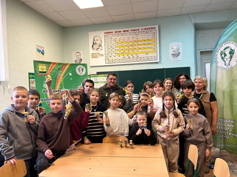 Діти разом із військовослужбовцем тримають виготовлені власноруч свічки з вощини