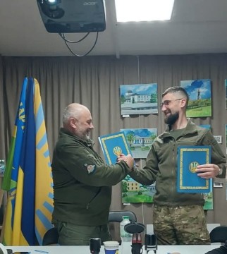 начальник Мар'їнської міської військової адміністрації Юрій Григулець та голова Великолучківської сільської територіальної громади Василь Коштура тиснуть руки після підписання меморандому про співпрацю