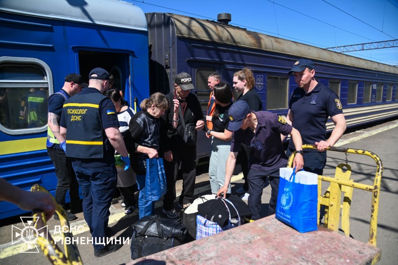 Рятувальники зустрічають людей з евакуаційного потяга, який придув до Рівненської області