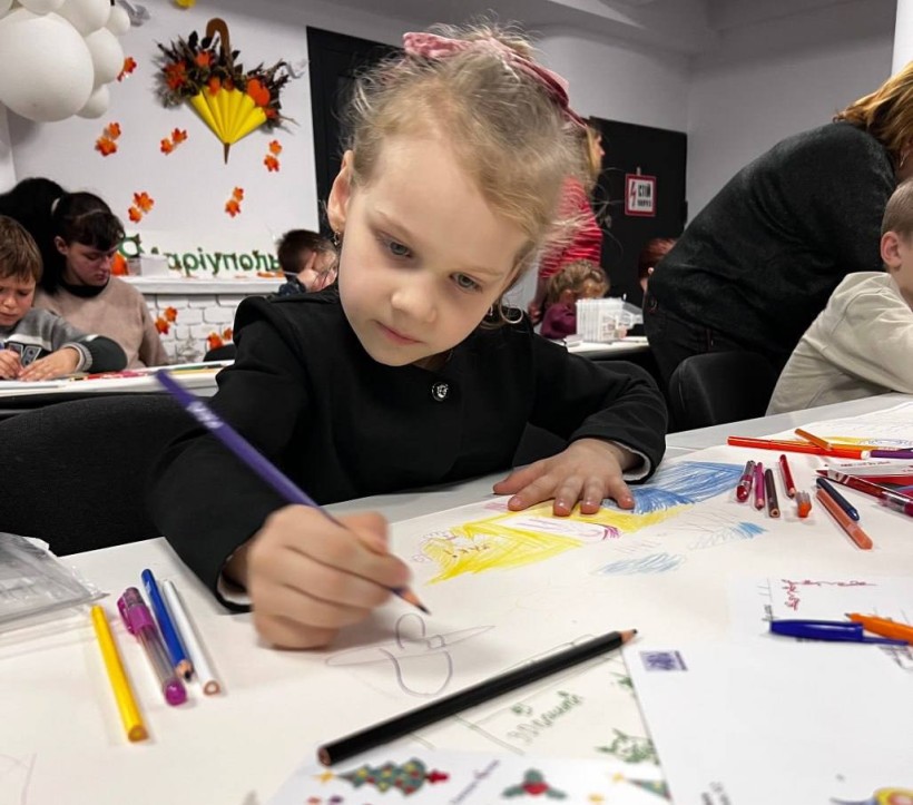 Дівчинка з Донецької області малює листівку Святому Миколаю