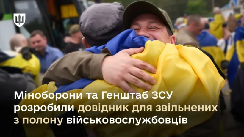 Чоловік обіймає військового якого звільнили з полону, на задньому фоні люди та українські прапори