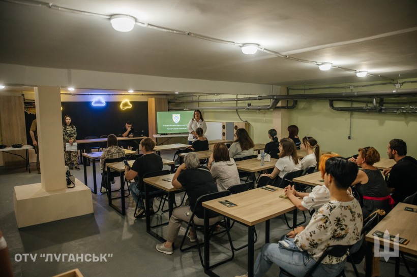 Учні та студенти на зустрічі з військовими в межах проєкту «Наша Донеччина. Наш дім. Наша фортеця». Презентація на екрані.