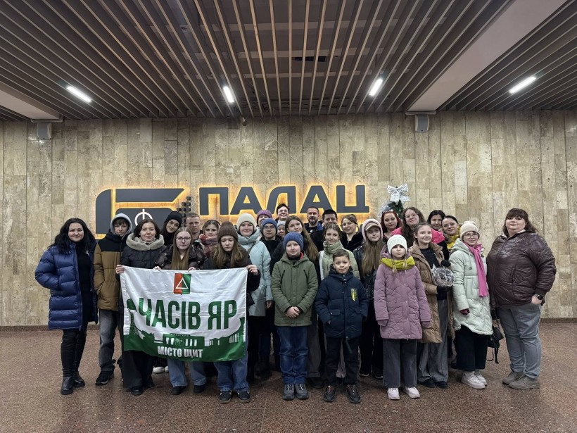 Спільне фото дітей та дорослих  з Часовоярської громади, які попереду тримають прапор громади.