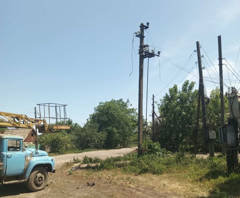 Автовишка та пошкоджена електроопора після російського обстрілу.
