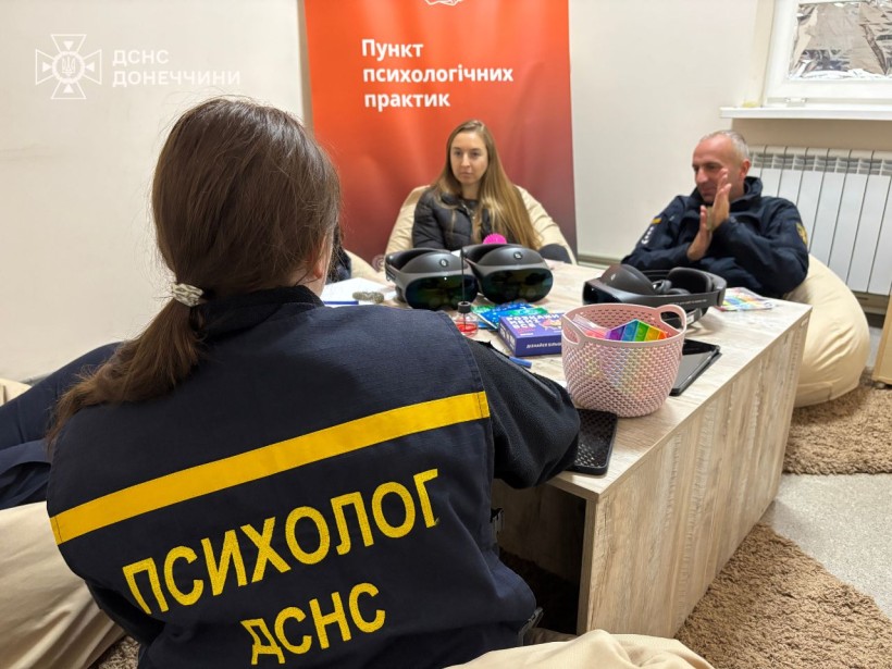 Психолог ДСНС проводить тренінг з рятувальниками та ветеранами. Всі сидять за столом, на якому лежать фарби та різні засоби для психологічного розвантаження.