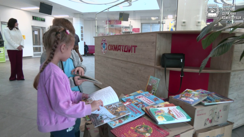 Діти розглядають передані книжки