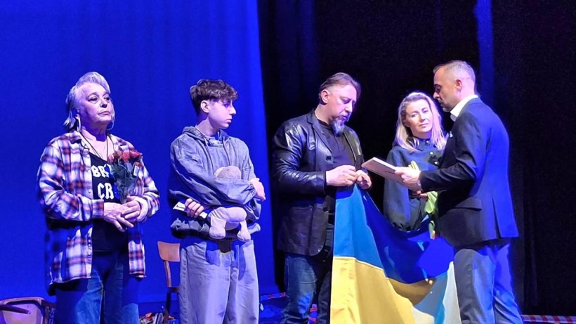 Актори театру на сцені з прапором України отримують відзнаку