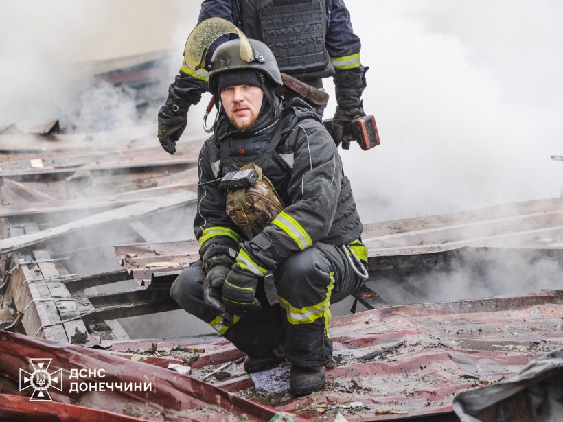 Рятувальники після тушіння пожежі, сидять на даху зруйнованого будинку.