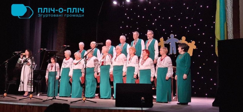 На сцені ансамбль народної творчості. Жінки та чоловіки одягнені у вишиванки.