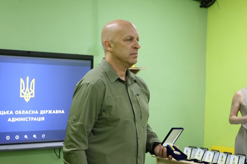 Вадим Філашкін тримає в руці нагрудний знак, призначений для нагородження енергетиків.