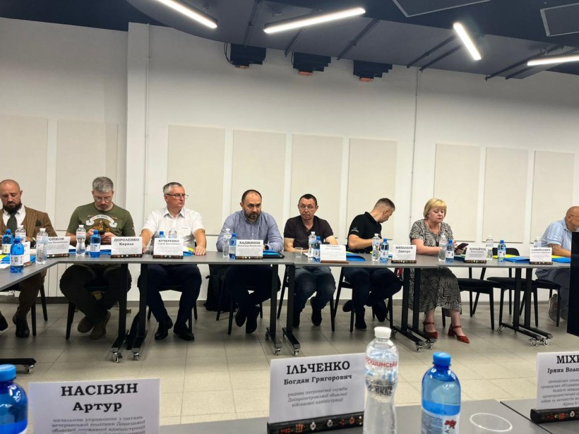 Учасники заходу слухають доповіді докладачів.