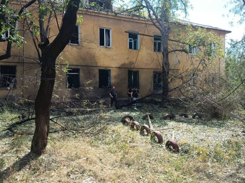Зруйновані квартири будинку у Краматорську та люди, які стоять поруч з будинком