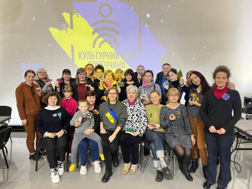 Дорослі відвідувачі хабу на спільному фото демонструють поробки