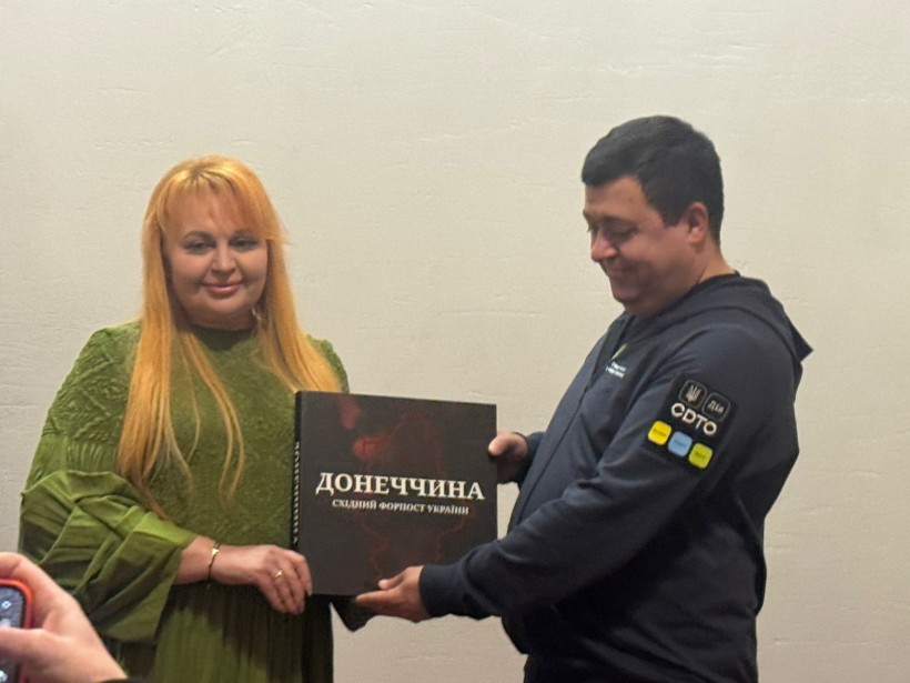 Урочистий момент передачі великої книги під назвою «Донеччина. Східний форпост України» між учасниками акції.