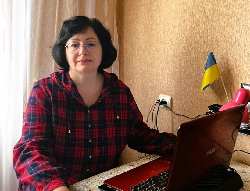Жінка з ноутбуком бере участь у засіданні комісії